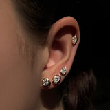 Molten solitaire stud earrings up the ear in round, oval, pearl, and marquise shapes set in 14k yellow gold.