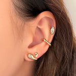 An AMANDA PEARL recycled 14k gold molten midi ear cuff with molten marquise stud worn in the helix above a molten stud with diamond pavé and small molten stud nested next to the molten stud.
