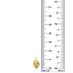 14K recycled Yellow Gold skull charm on white background with ruler measuring, 14mm tall