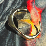 14k recyled Gold Molten Cuff Bracelet, pictured on a Molten lava image