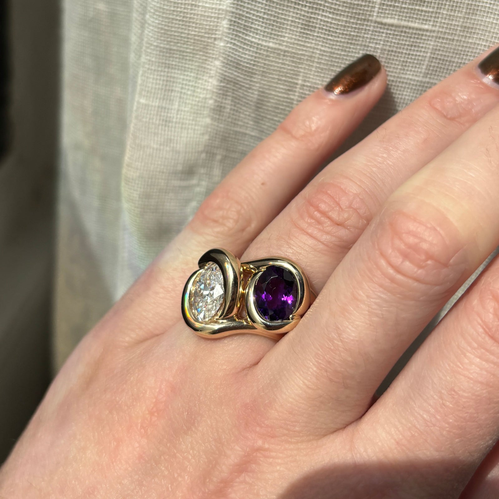 Molten knot ring with deep, rich purple amethyst gemstone paired with a molten knot ring with diamond on a model's hand.