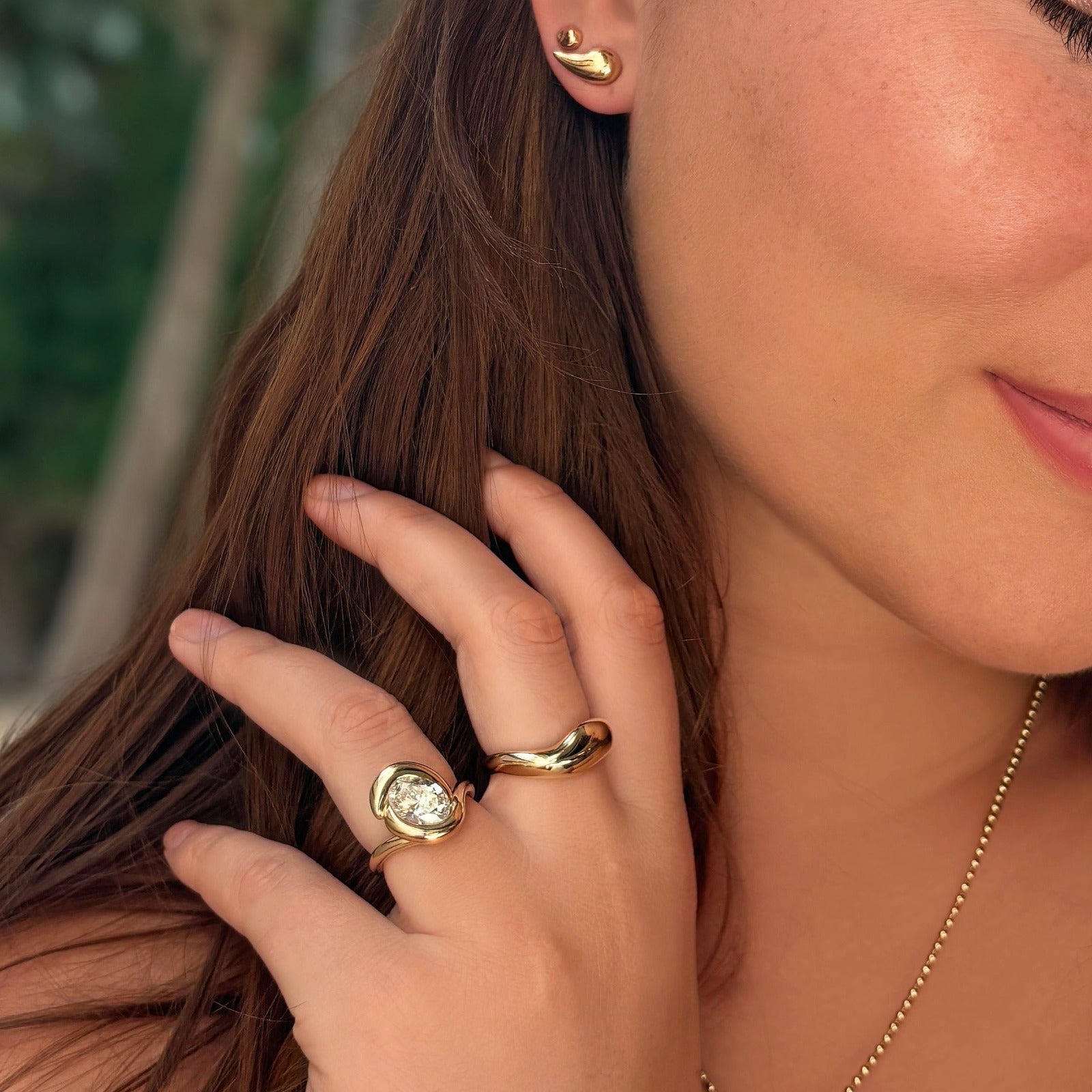 14K recycled gold Molten Ring styled on a hand with the molten knot ring