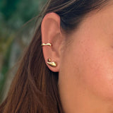 Small liquid round 14K recycled yellow gold stud earring on ear, styled with molten midi cuff and small molten stud