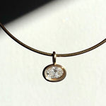 Recycled 14k yellow gold molten solitaire charm with oval diamond, hanging from an omega choker.