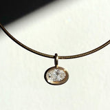 Recycled 14k yellow gold molten solitaire charm with oval diamond, hanging from an omega choker.