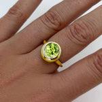 AMANDA PEARL recycled 14k gold Molten Solitaire Ring with peridot gemstone on a model's hand.