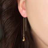 14K Yellow Gold Molten Gold Drop on a gold chain hanging from an ear. 
