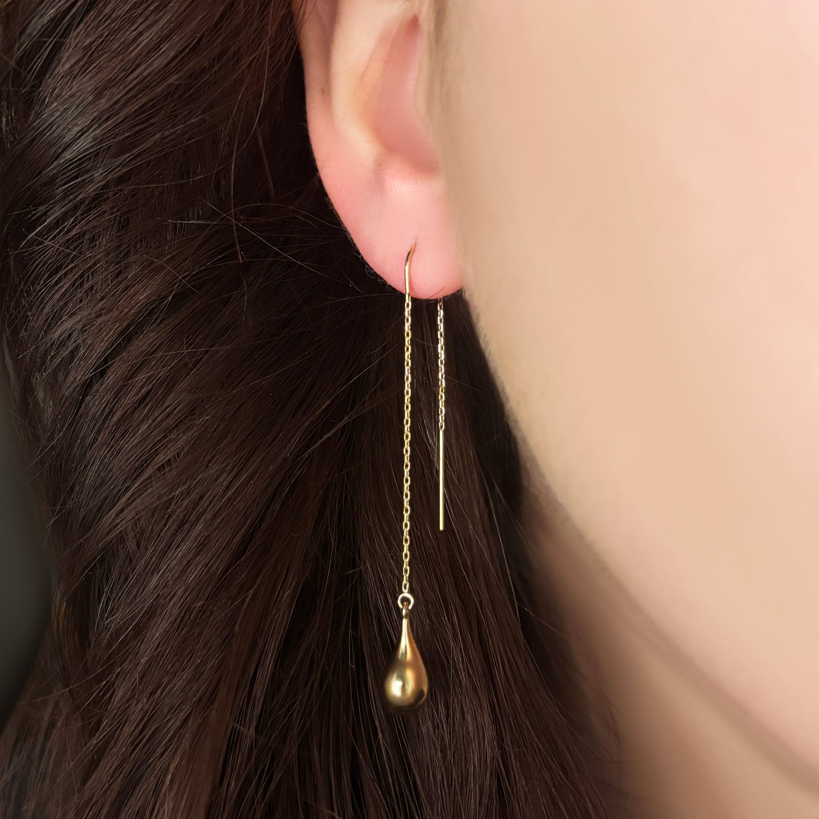 14K Yellow Gold Molten Gold Drop on a gold chain hanging from an ear. 