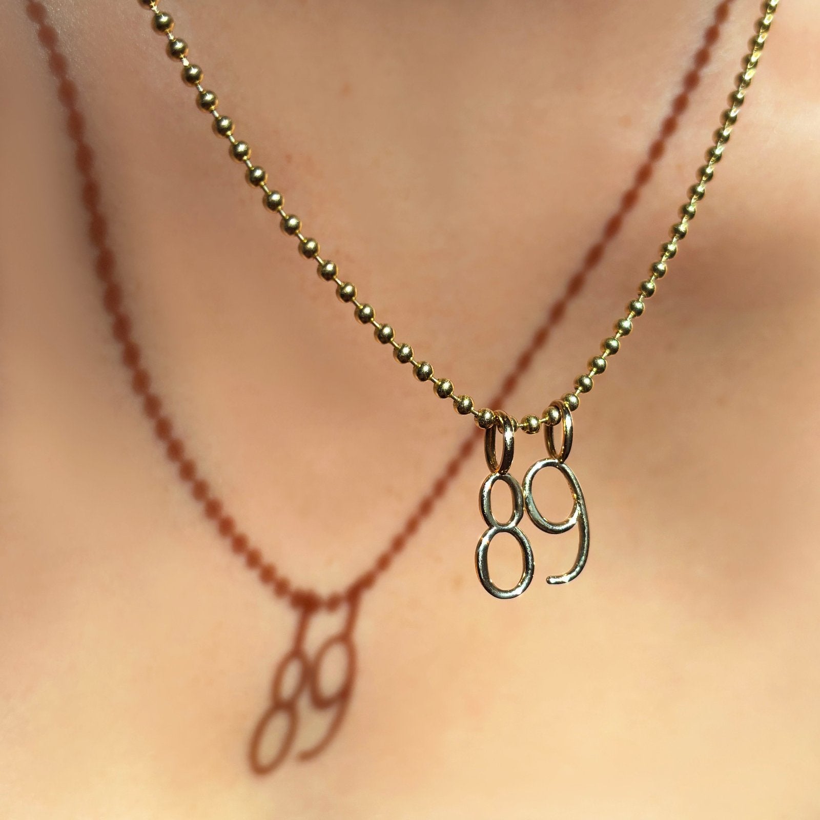 14K Recycled Yellow Gold Number 8 and 9 Charm styled on a chain