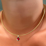 Omega chain with molten knot charm with round rose cut ruby on the neck.
