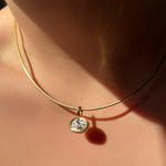 Adjustable omega choker with oval molten solitaire charm on the neck.