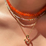 14k recycled gold Plain Ripple Charm. Hanging from a diamond cut cable chain necklace layered with a Tourmaline Slim Gemstone necklace and Orange Faceted Opal Necklace