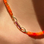 14K Gold Small Ruby Charm Lock styled on an Orange Faceted Opal Necklace on a neck