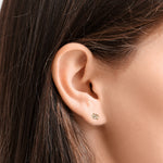 Close-up of an ear wearing an AMANDA PEARL Elements ethical diamond stud earring with a blurred background.