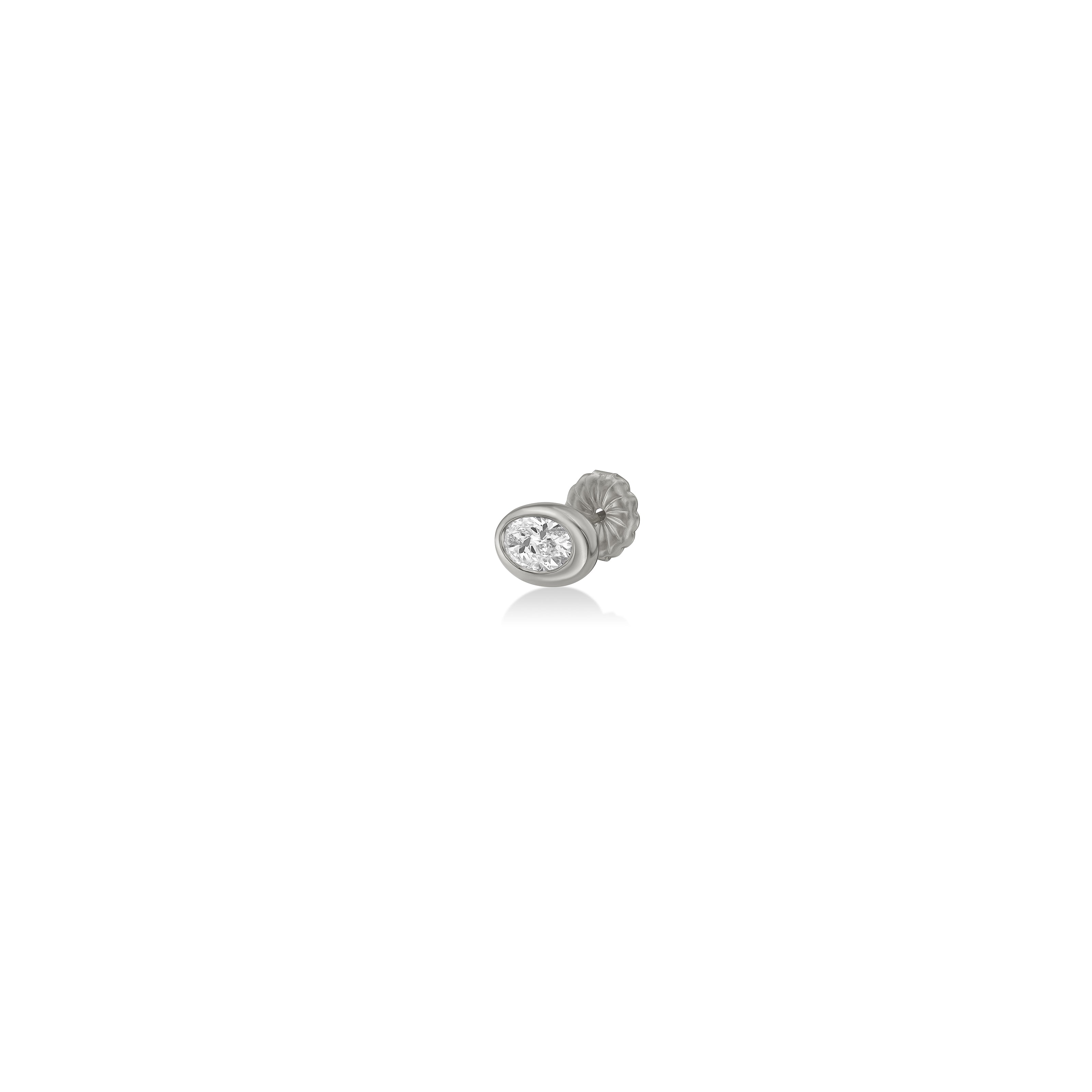 An oval molten solitaire stud shot from three quarters view on in 14K yellow gold, with a diamond.