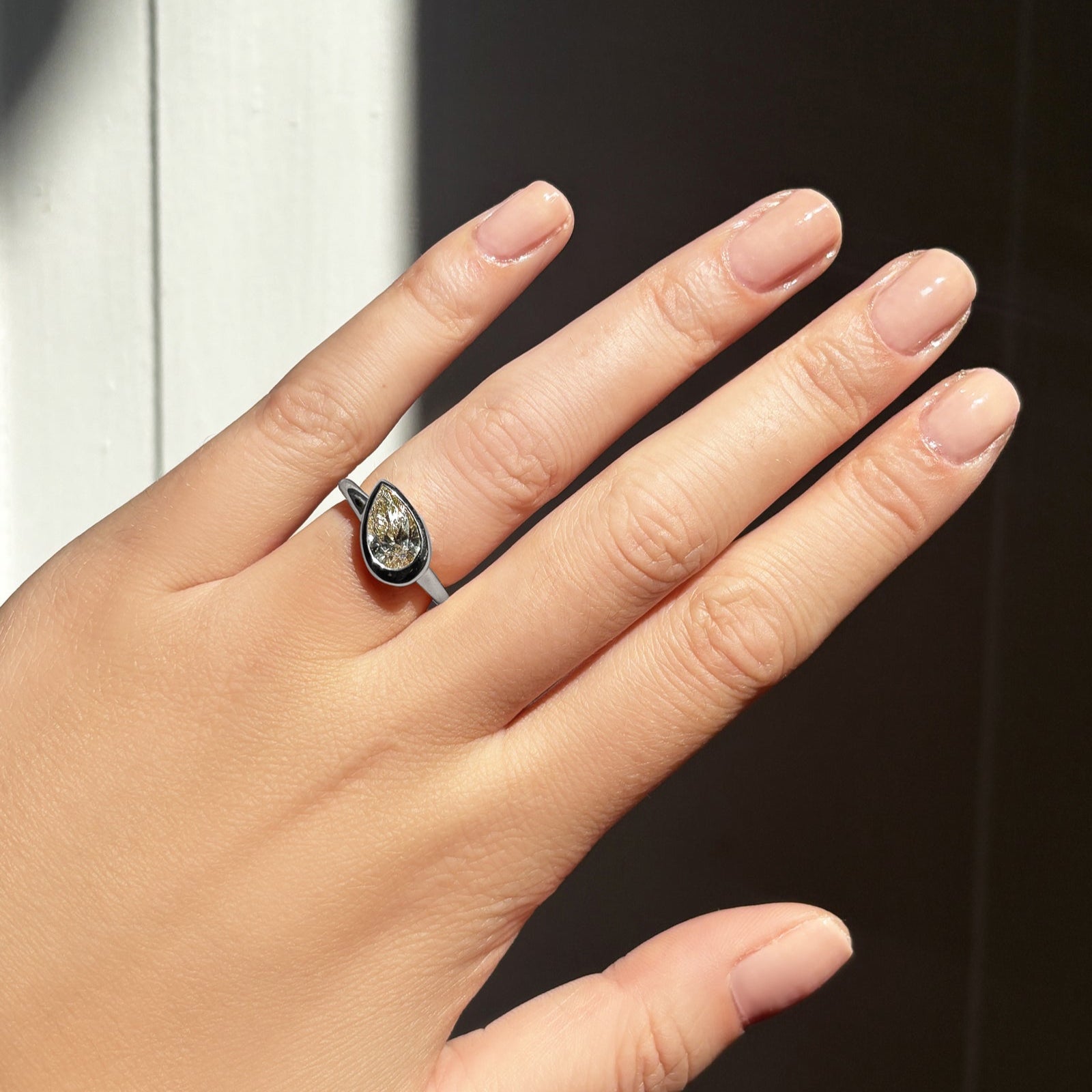 Molten Solitaire Ring with Pear Diamond on the hand.
