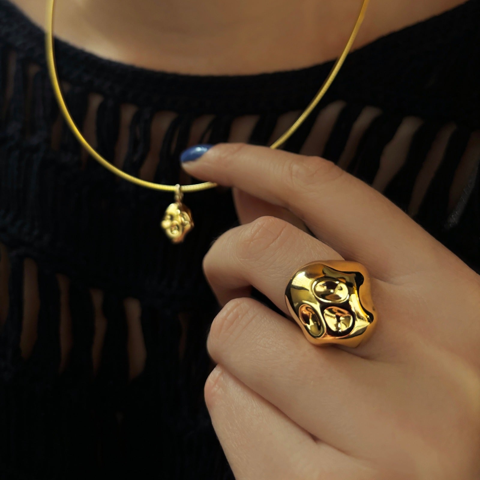 14K recycled yellow gold choker with skull charm, with a skull ring styled on a hand