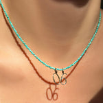 14K Recycled Yellow Gold Number Zero and six Charm styled on a turquoise slim gemstone