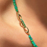14k gold Small Diamond Charm Lock with emerald pavé on a white background styled on a neck locked onto oval clasps of a Green Faceted Opal Necklace.