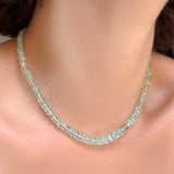 Single strand of faceted aquamarine rondelles on a model's neck.