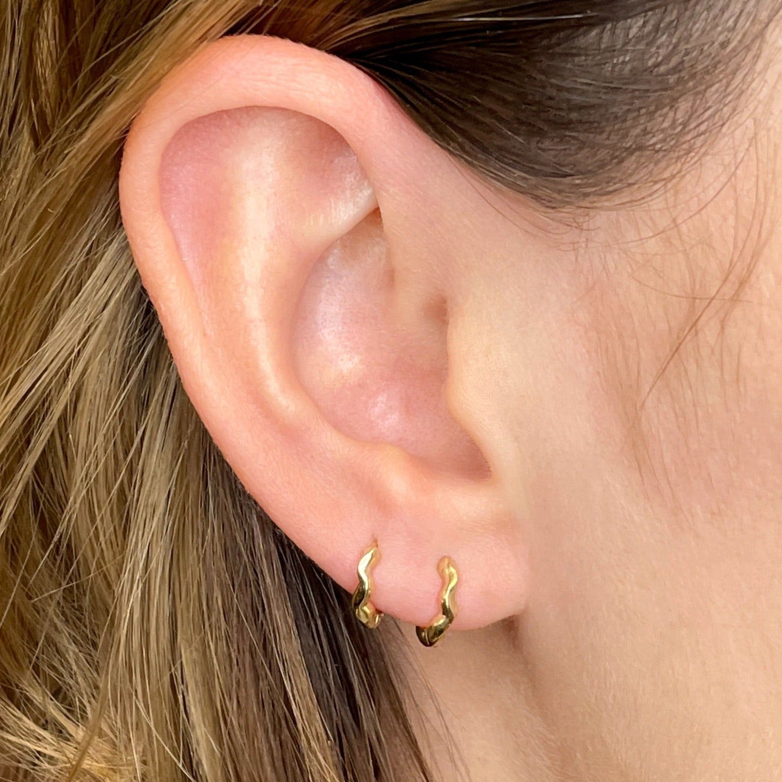 14K Recycled Gold Ripple Huggies styled together on an ear
